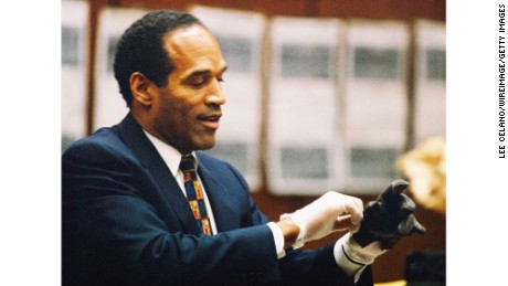 O.J. Simpson tries on a leather glove allegedly used in the killings of Nicole Brown Simpson and Ronald Goldman during testimony in Simpson&#39;s murder trial on June 15, 1995, in Los Angeles.