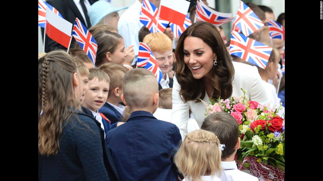 Children welcome Kate in front of the presidential palace in Warsaw upon the royal family&#39;s arrival in Poland.