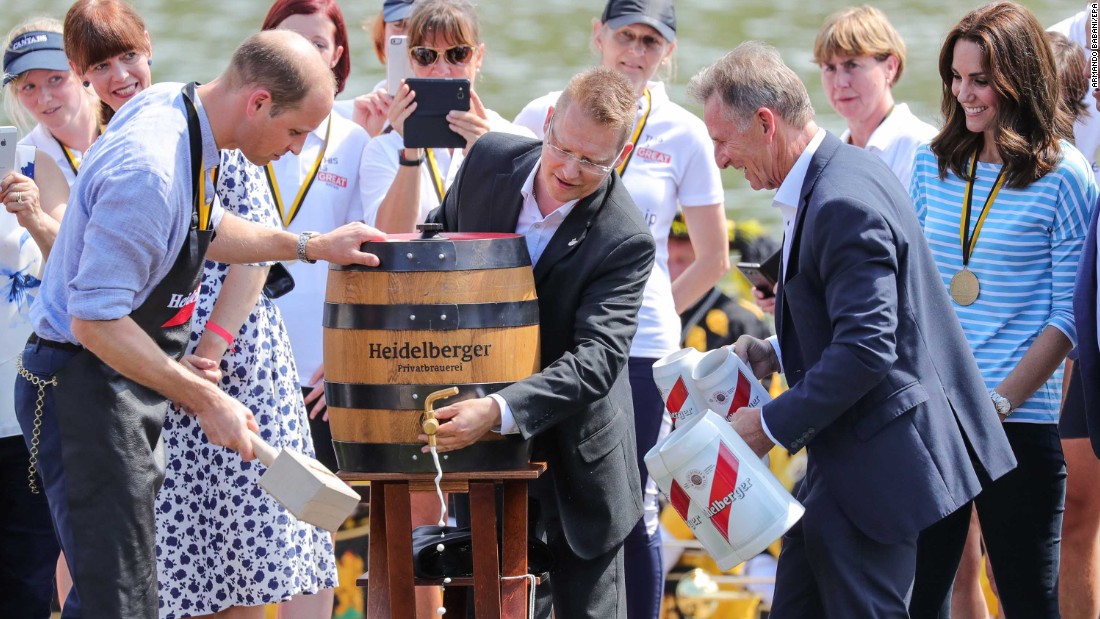 Prince William hammers a tap into a beer barrel as Kate, far right, watches on July 20 in Heidelberg, Germany.