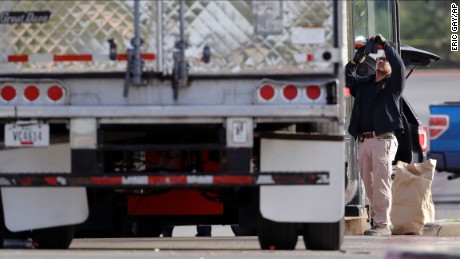 Evidence is collected at the scene where eight people were found dead in a tractor-trailer loaded with multiple others, outside a Walmart store in stifling summer heat in what police are calling a horrific human trafficking case, Sunday, July 23, 2017, in San Antonio, Texas. 