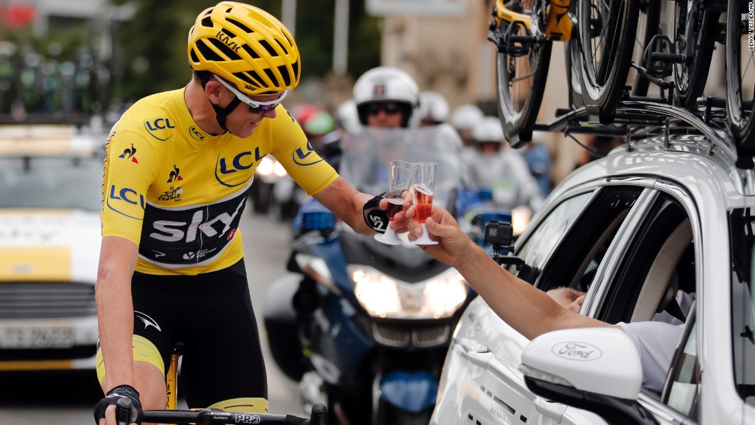 Froome toasts a member of his team during the last stage of the Tour de France race.