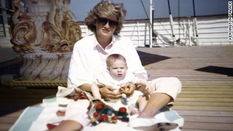 Princess Diana holds a baby Prince Harry in her arms as she sits on board the Royal Yacht Brittania.