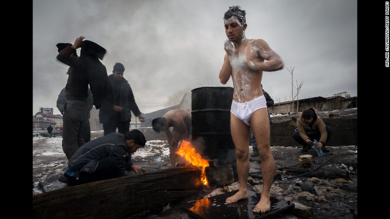 Migrants bathe outside near a makeshift shelter in an abandoned warehouse in Subotica, Serbia, in January 2017.