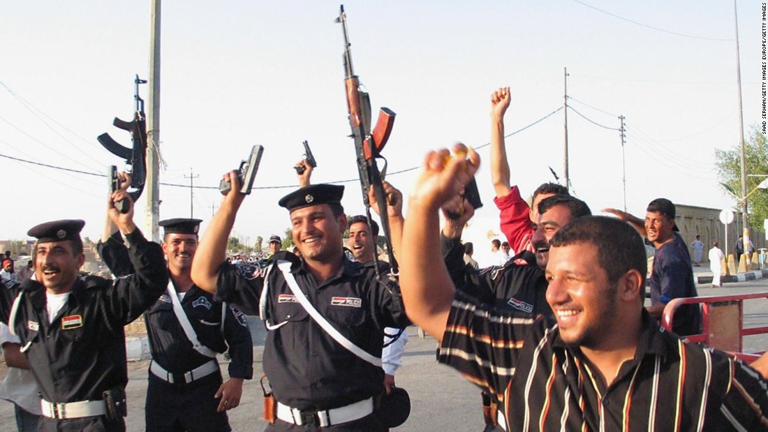Many fired their weapons in the air in celebration, including these policemen in the Shiite city of Najaf south of Baghdad.