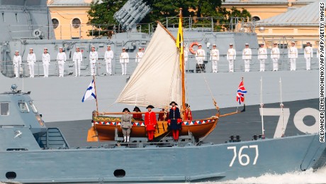 Russian sailors stand in attention on a military vessel carrying a replica of a boat of Peter The Great during a naval parade in St. Petersburg.