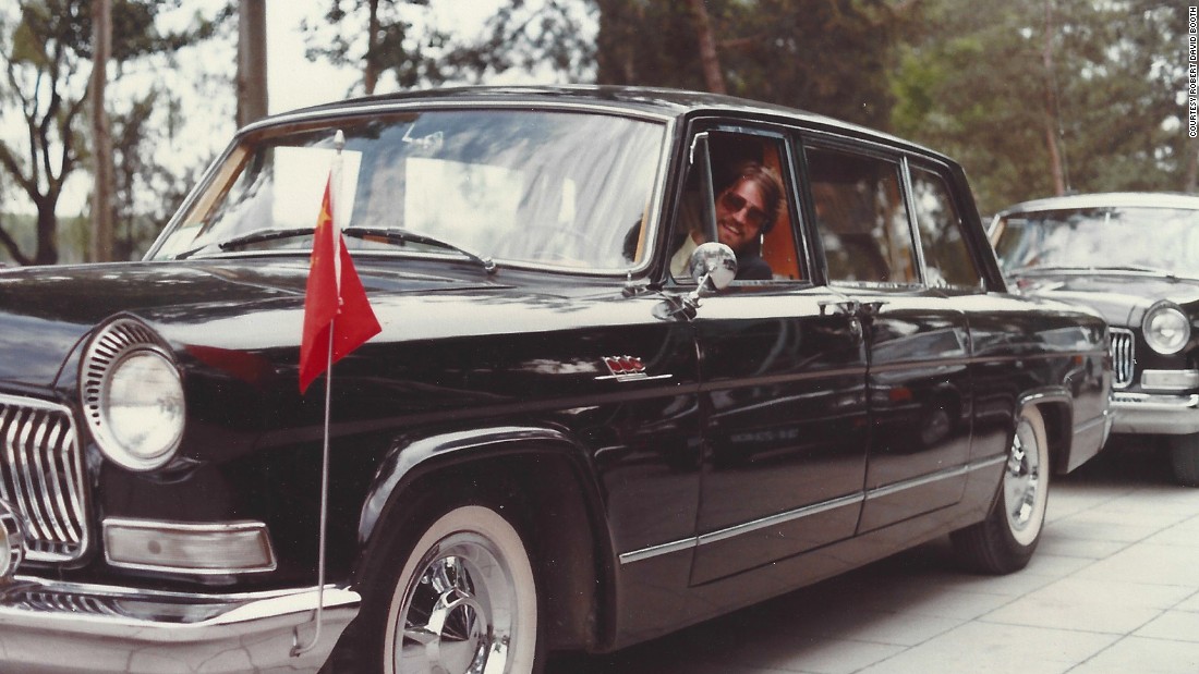 Booth poses behind the wheel of a Chinese diplomatic car in Beijing in 1981. 