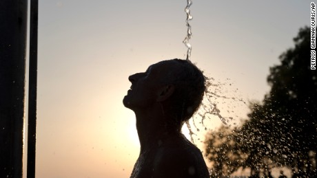 A man takes a shower at a beach of Alimos suburb, in Athens  Wednesday, July 12, 2017. A summer heatwave has hit Greece, with temperatures reaching a high of 39 degrees Celsius (102 Fahrenheit) in Athens.(AP Photo/Petros Giannakouris)