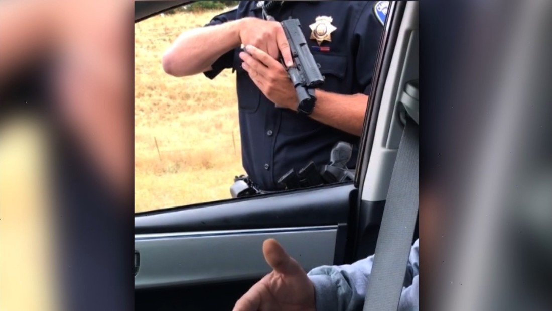 cop pointing gun down stock photo
