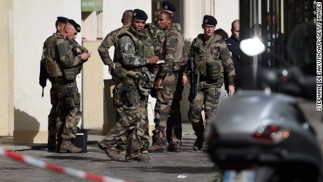 French soldiers gather at the site where a car slammed into soldiers on patrol in Levallois-Perret, outside Paris, on August 9, 2017.
