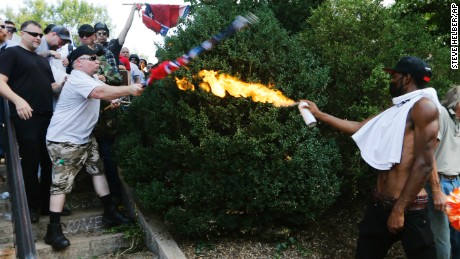 A counter demonstrator uses a lighted spray can against a white nationalist demonstrator at the entrance to Lee Park in Charlottesville, Virginia, Saturday, August 12, 2017. Gov. Terry McAuliffe declared a state of emergency and police dressed in riot gear ordered people to disperse after chaotic violent clashes between white nationalists and counter protestors. 