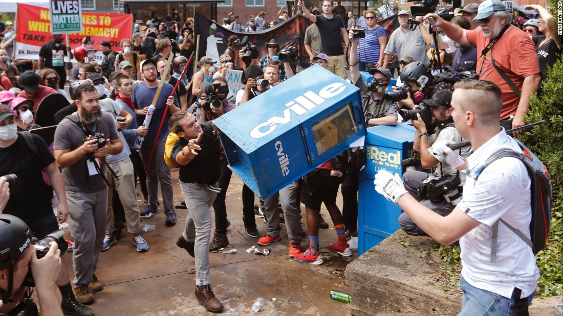 A counterprotester throws a newspaper box at a right-wing rally member at the entrance to Emancipation Park.