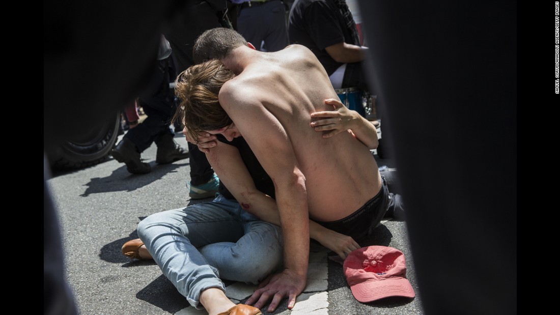 A man embraces an injured woman after a car rammed into the crowd. 