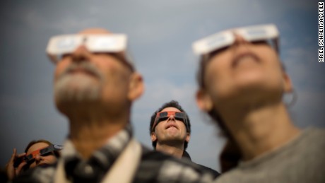 Israelis watch at a partial solar eclipse in the town of Givatayim near Tel Aviv, Israel, Tuesday, Jan. 4, 2011. A partial solar eclipse began Tuesday in the skies over the Mideast and will extend across much of Europe. (AP Photo/Ariel Schalit)