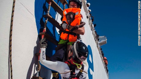 A member of Aquarius, a rescue ship run by NGO SOS Méditerranée and Doctors Without Borders, brings a young girl on board in August 2017.