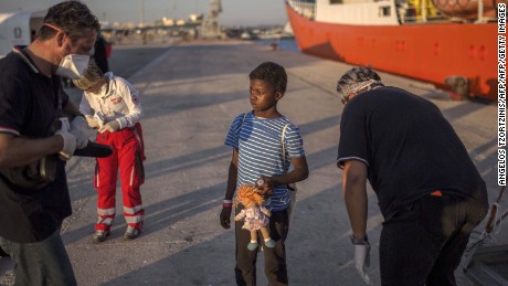 A child, who was aboard the Aquarius rescue ship, receives flip-flops upon her arrival in the port of Pozzallo, Italy, in August 2017.  
