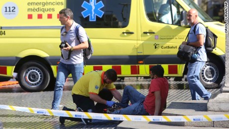 An injured person is treated Thursday after a van jumped the sidewalk in Barcelona&#39;s Las Ramblas area. 