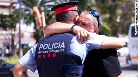A man embraces a police officer on the spot where five terrorists were shot by police on August 18, 2017 in Cambrils, Spain. Fourteen people were killed and dozens injured when a van hit crowds in the Las Ramblas area of Barcelona on Thursday. Spanish police have also killed five suspected terrorists in the town of Cambrils to stop a second terrorist attack.