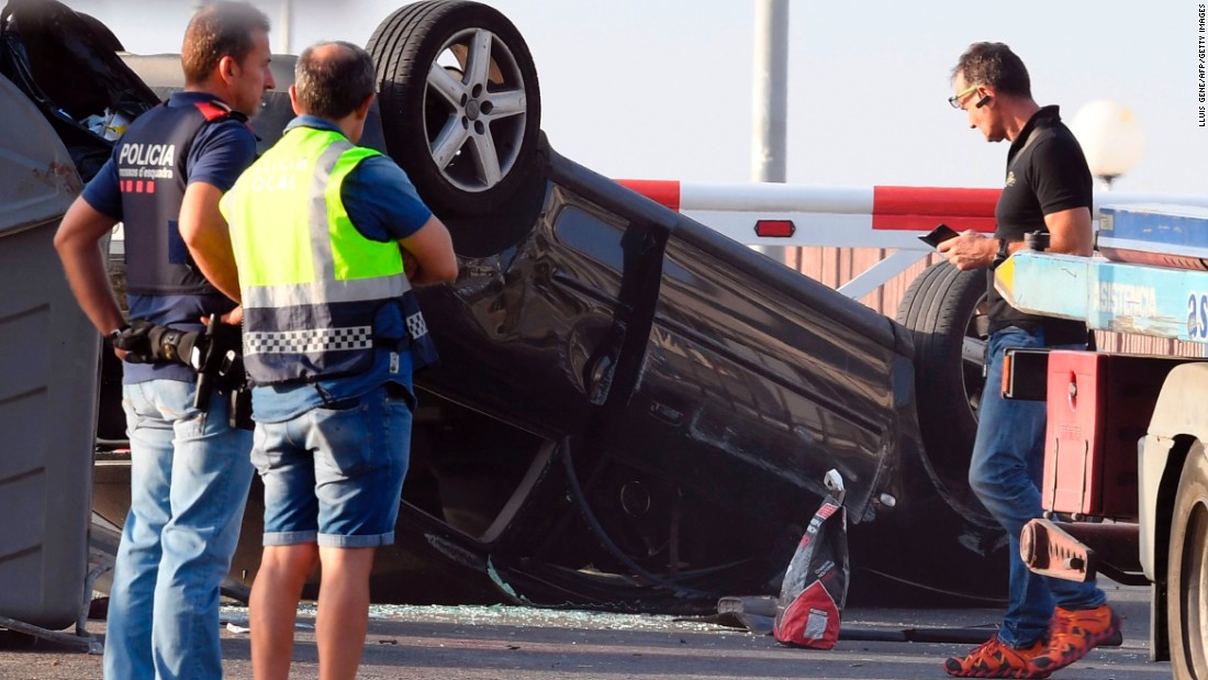 Police officers investigate a car in Cambrils.