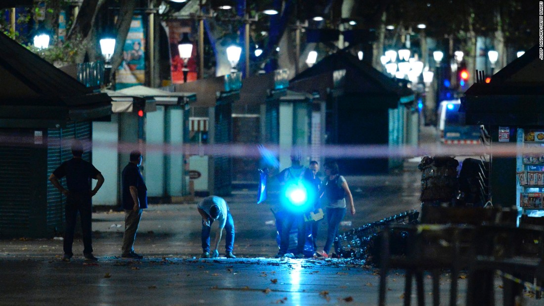 Police officers check the area after towing away the van.