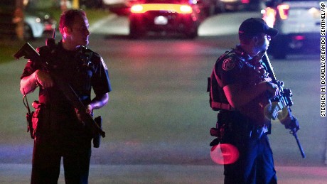 Two law enforcement officers stand guard outside Osceola Regional Medical Center after two Kissimmee police officers were shot Friday, August 18, 2017, in Kissimmee, Florida. Police said one officer was killed and another gravely injured. 