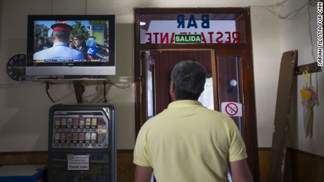 A taxi driver watches a press conference with Spanish authorities broadcast on a television in Hostal Montecarlo.