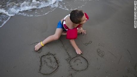 Romera and Gonzalez&#39; 4-year-old son sketches in the sand on Playa Cementera.