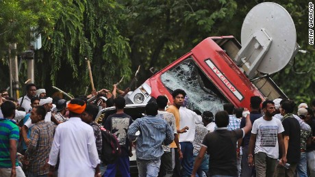 Dera Sacha Sauda sect members overturn an OB van on the streets of Panchkula, India, Friday, Aug. 25, 2017. 