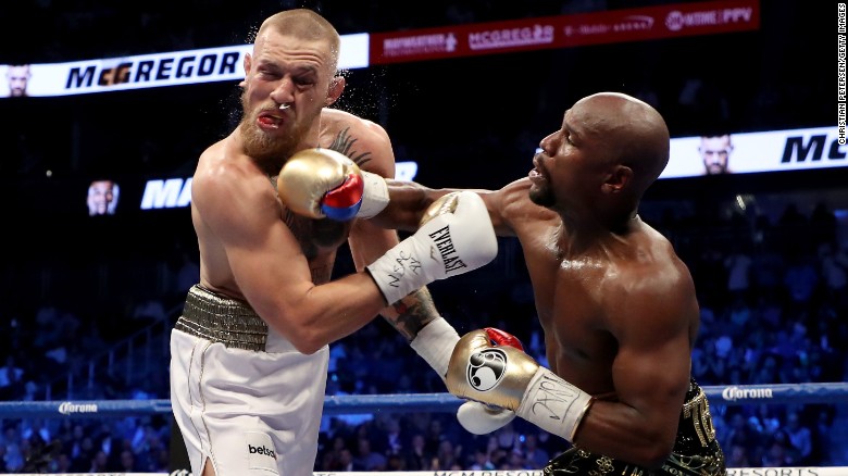 LAS VEGAS, NV - AUGUST 26:  (R-L) Floyd Mayweather Jr. throws a punch at Conor McGregor during their super welterweight boxing match on August 26, 2017 at T-Mobile Arena in Las Vegas, Nevada.  (Photo by Christian Petersen/Getty Images)