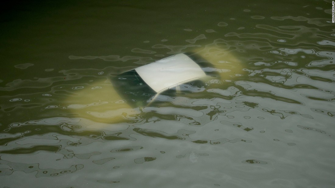 A car is submerged by floodwaters on a freeway near downtown Houston.