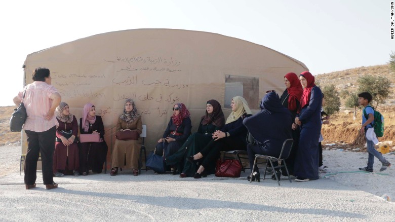 Mothers and teachers sit outside the tent in Jub El-Thib.