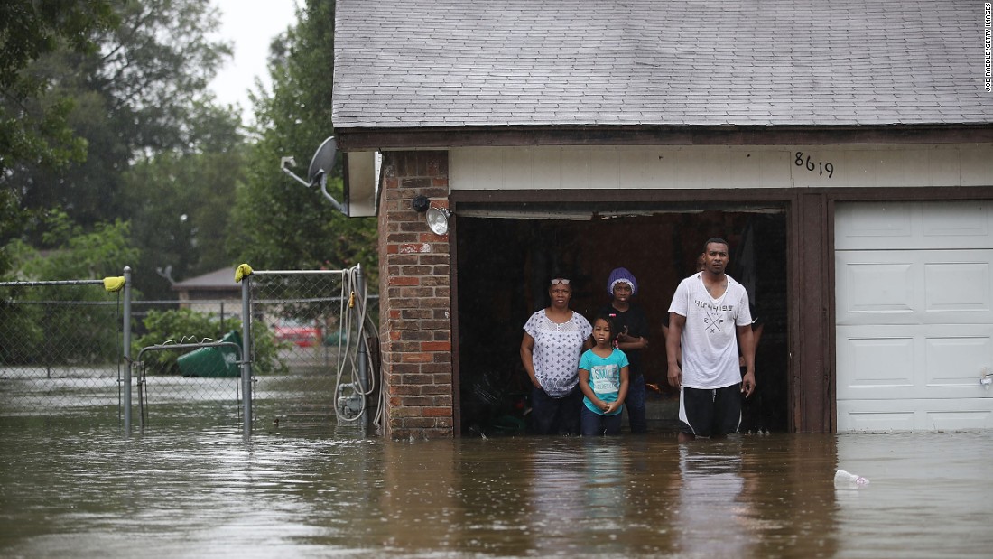 People wait to be rescued from their flooded home in Houston.