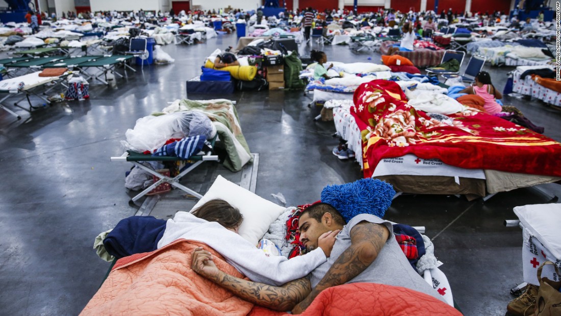 Tammy Dominguez and her husband, Christopher, sleep on cots at the George R. Brown Convention Center, where thousands of people were taking shelter in Houston.