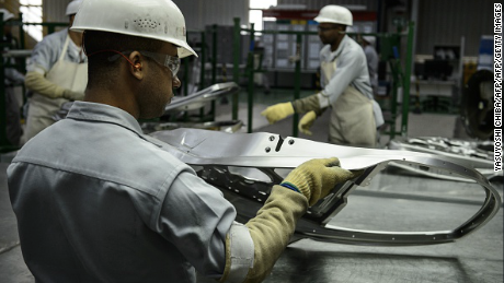 Workers check stamped parts at the production area of the March and Versa models at Nissan's Industrial Complex in Resende, 160 km west of Rio de Janeiro, Brazil, on Februrary 3, 2015. The Nissan plant in Brazil will be able to produce 200,000 cars and utility vehicles per year. The company aims to achieve 5 percent of the market share by 2016 in Brazil, the fourth largest automotive market in the world. AFP PHOTO / YASUYOSHI CHIBA        (Photo credit should read YASUYOSHI CHIBA/AFP/Getty Images)