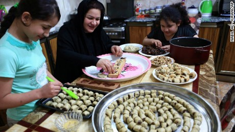 An Iraqi mother and her children prepare cookies for holiday in Basra, Iraq.