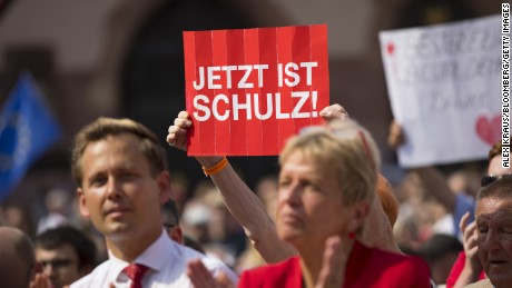 An SPD supporter holds up a &quot;Now Is Schulz&quot; poster at a campaign rally.