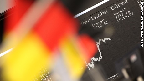 German flags are pictured in front of a display showing the German stock market index DAX at the stock exchange in Frankfurt, Germany, on July 14, 2014. AFP PHOTO / DANIEL ROLAND        (Photo credit should read DANIEL ROLAND/AFP/Getty Images)