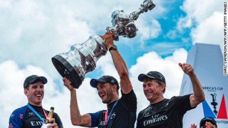 Emirates Team New Zealand helmsman Peter Burling and trimmer Blair Tuke and shore crew manager Sean Regan hoist the America&#39;s Cup in the Great Sound during the 35th America&#39;s Cup June 26, 2017 in Hamilton, Bermuda. / AFP PHOTO / Chris CAMERON        (Photo credit should read CHRIS CAMERON/AFP/Getty Images)