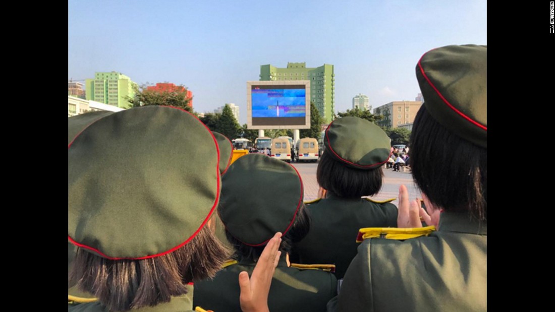 The crowd applauds as North Korean TV airs footage of their latest missile launch outside Pyongyang Station on August 30, 2017.