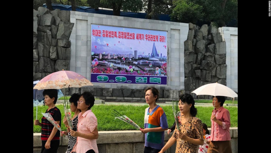 Pyongyang residents walk past a poster marking the 69th DPRK Foundation Day on September 9. It reads &quot;Let the entire world look up to the great Kim Il Sung nation and Kim Jong Il Korea.&quot;