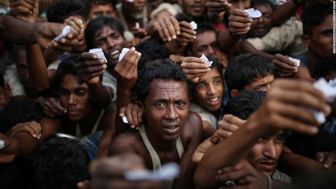 Rohingya men reach out for relief supplies on September 9, at a refugee camp in Bangladesh.