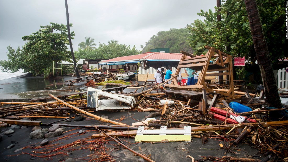 People stand near debris at a restaurant in Le Carbet, Martinique, on September 19.