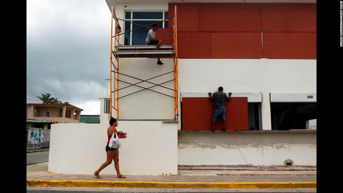 People in Luquillo, Puerto Rico, board up windows of a business on September 19.