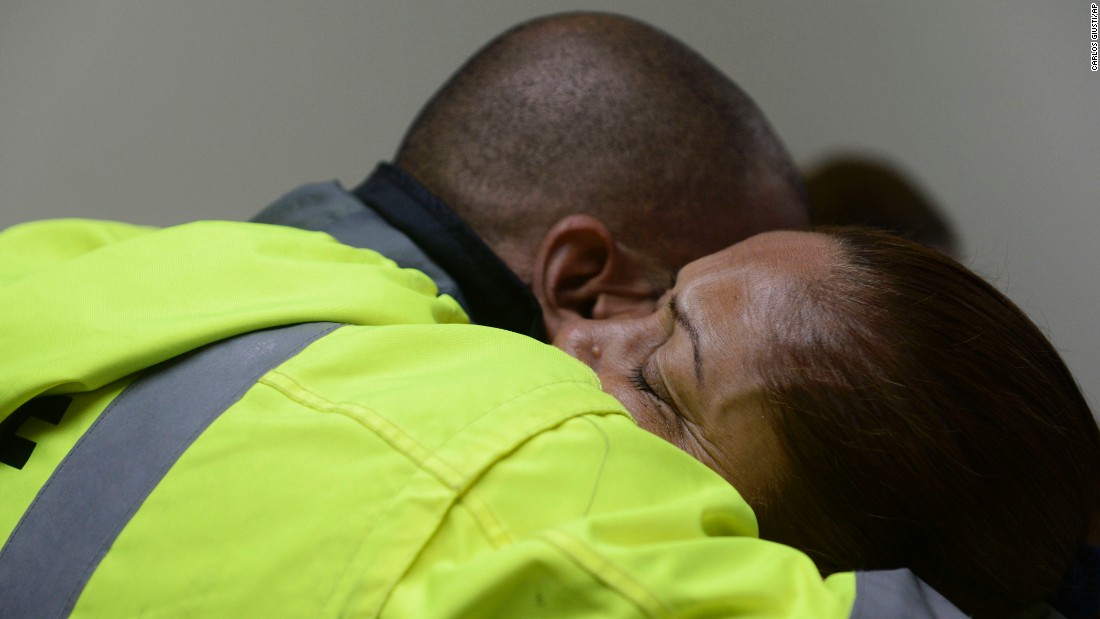 Members of a rescue team embrace as they wait to help in Humacao on September 20.