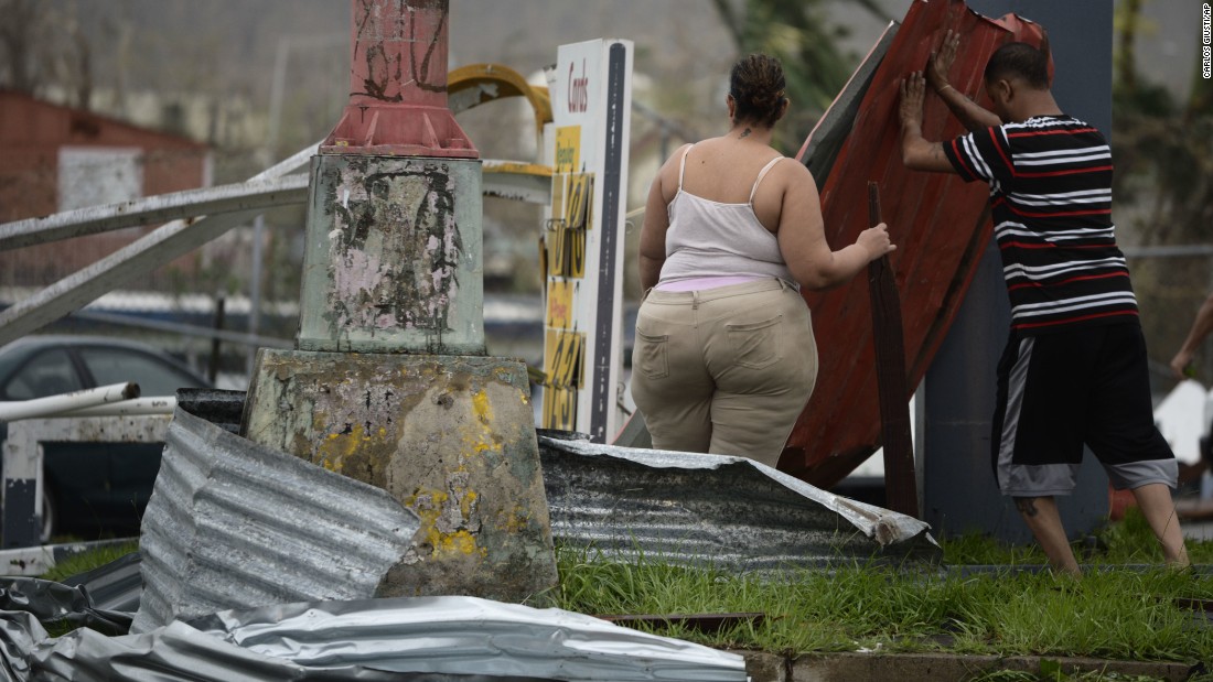 Residents move aluminum panels from an intersection in Humacao on September 20. 