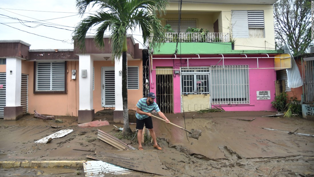 A man cleans a muddy street in Toa Baja, Puerto Rico, on September 22.