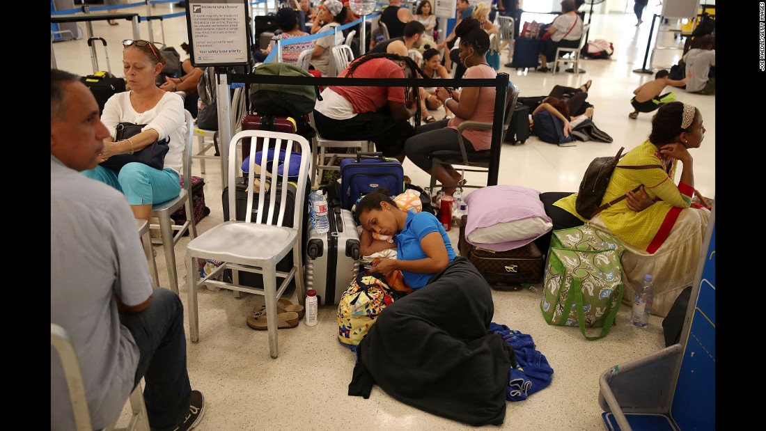 Yancy Leon rests at the Luis Muñoz Marin International Airport near San Juan on September 25. She&#39;s been waiting in line for two days to get a flight out.