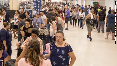Travelers stand in line at Luis Muoz Marn International Airport in San Juan, Puerto Rico, on Monday, Sept. 25, 2017. Hurricane Maria hit the Caribbean island last week, knocking out electricity throughout the island. The territory is facing weeks, if not months, without service as utility workers repair power plants and lines that were already falling apart. Photographer: Alex Wroblewski/Bloomberg via Getty Images