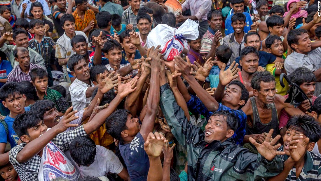 People scramble to catch food distributed by aid groups on September 18 at the Balukhali refugee camp in Bangladesh.