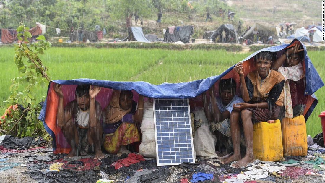 Rohingya refugees take cover from monsoon rains on September 17 in the Balukhali refugee camp in Bangladesh.