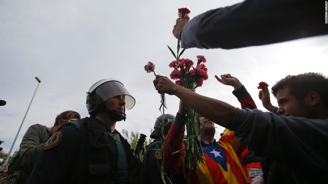 People try to offer flowers to a civil guard at the entrance of a sports center, assigned to be a referendum polling station by the Catalan government in Sant Julia de Ramis, near Girona, Spain, October 1.